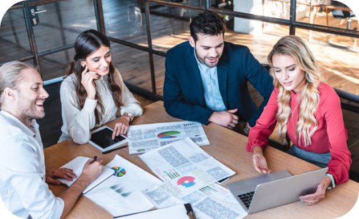 A business team collaborates around a table reviewing data and charts for vet training.