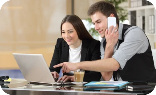 Two business professionals collaborate on a laptop and phone, demonstrating effective communication for quality vet training.