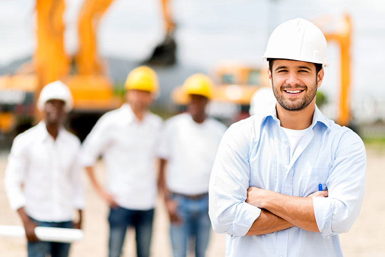 A construction worker smiles with colleagues on a site, demonstrating safety practices in VET training.