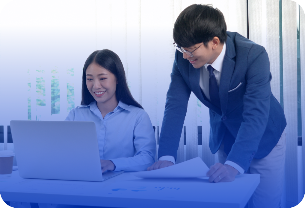 Two business professionals collaborate on a laptop and documents, showcasing CAQA Courses' RPL Kit.